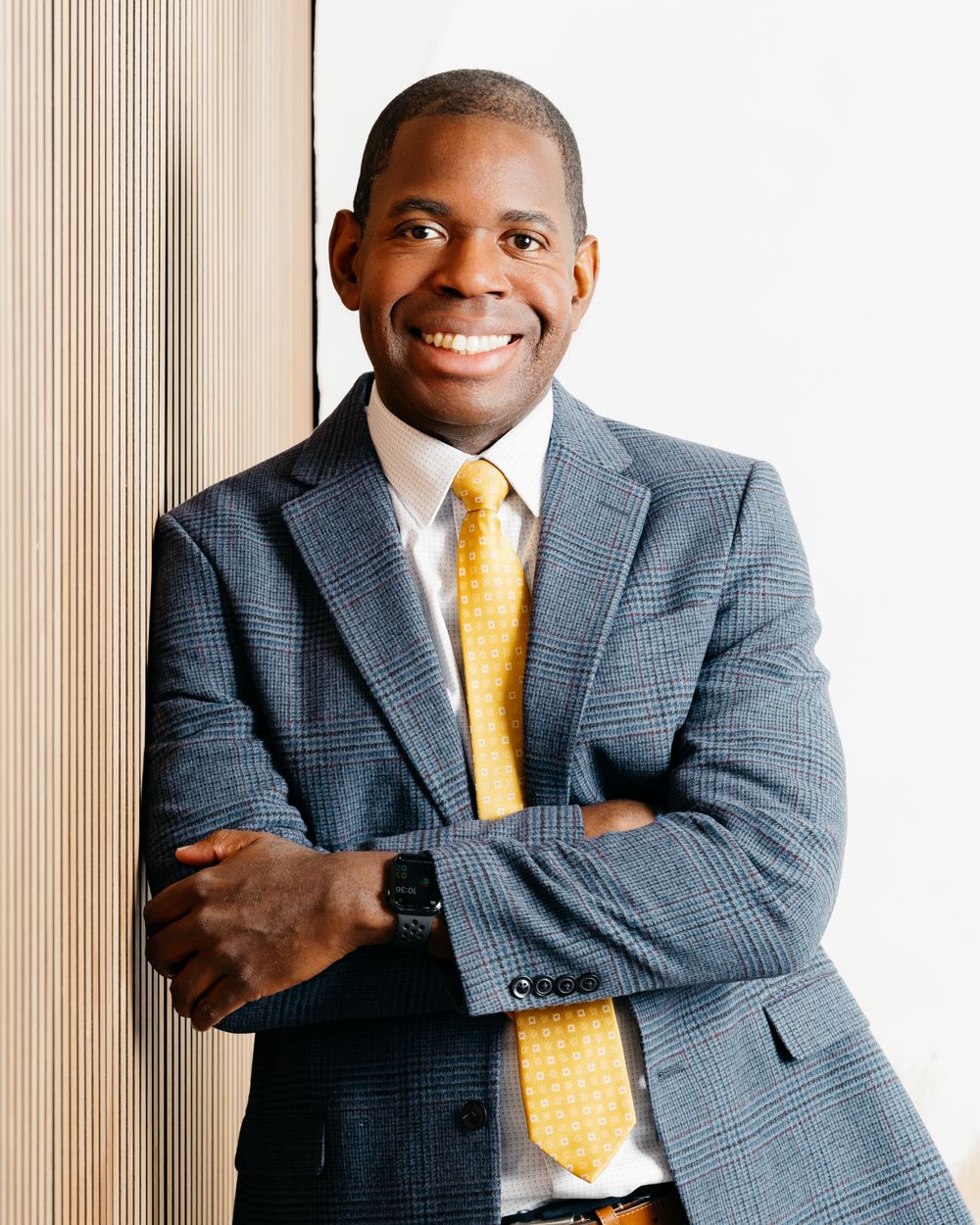 Des Dorsey in a suit with arms crossed