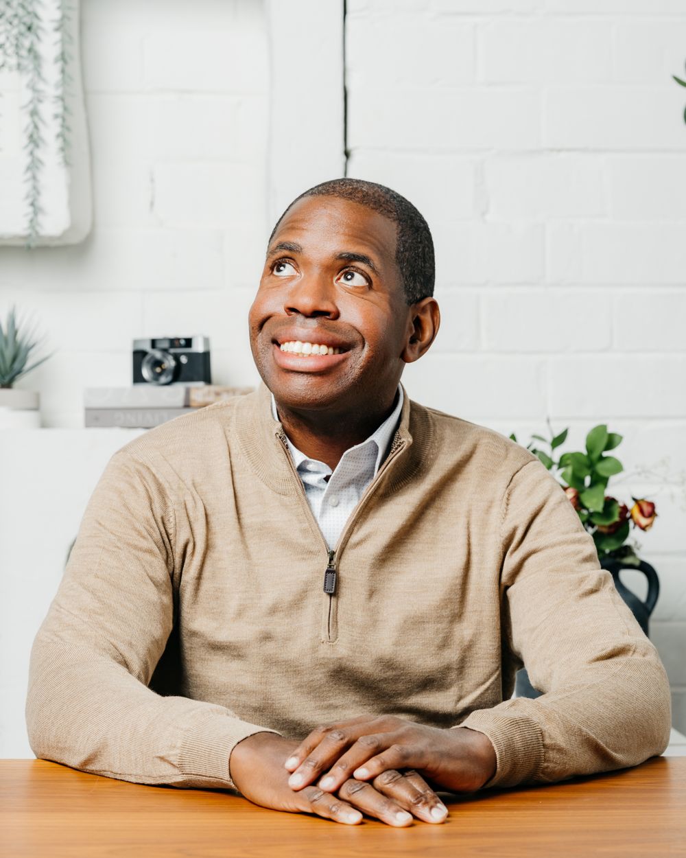 Des Dorsey in a sweater, seated at a table